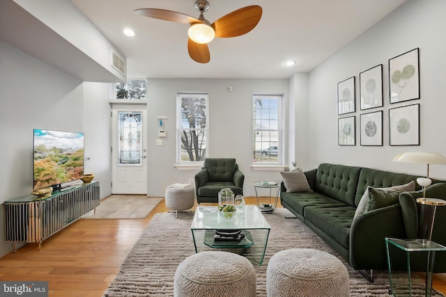 living room with light hardwood / wood-style flooring and ceiling fan