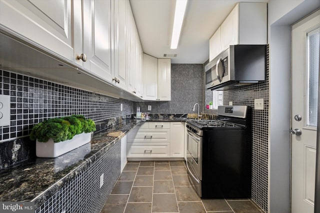 kitchen featuring decorative backsplash, sink, stainless steel appliances, and white cabinets