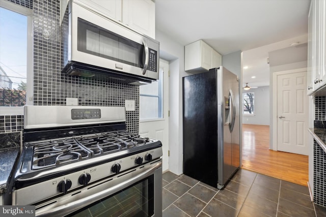 kitchen with appliances with stainless steel finishes, white cabinetry, and tasteful backsplash