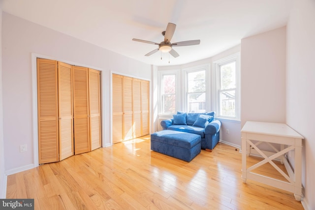 living area with light wood-type flooring and ceiling fan