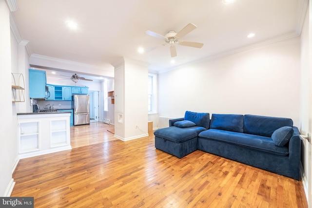 living room featuring ceiling fan, ornamental molding, and light hardwood / wood-style floors