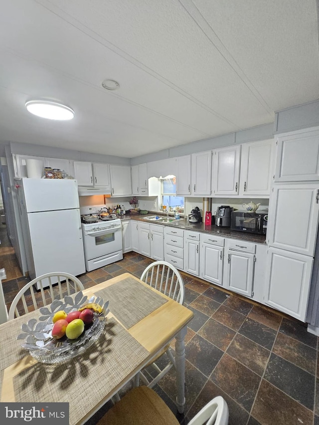 kitchen with sink, white appliances, white cabinetry, and a textured ceiling