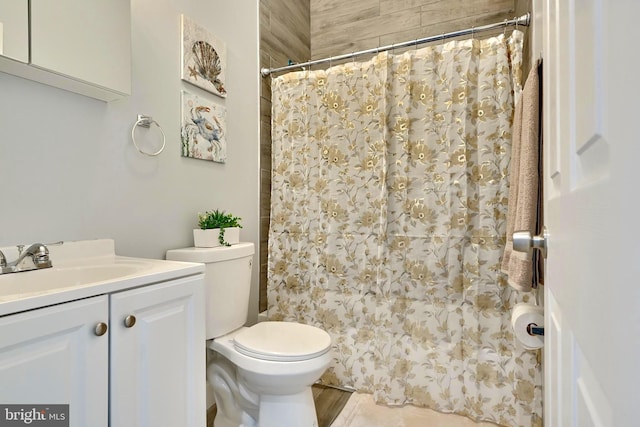 bathroom featuring curtained shower, vanity, and toilet