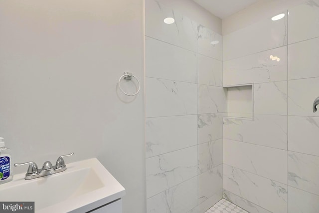 bathroom featuring a tile shower and vanity