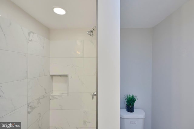 bathroom with toilet and tiled shower