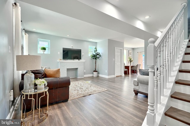 living room with hardwood / wood-style floors and a brick fireplace