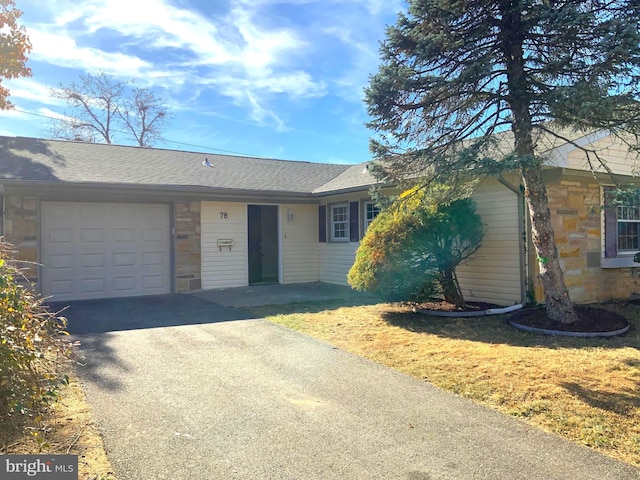 single story home with a garage and a front lawn