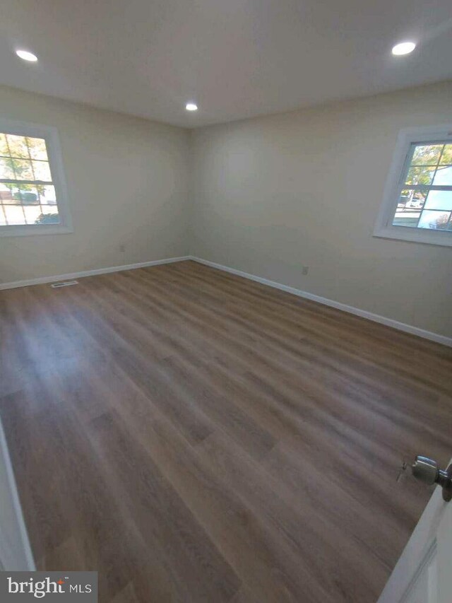 unfurnished room featuring wood finished floors, baseboards, and recessed lighting