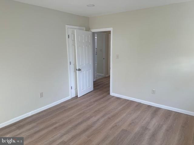 empty room featuring baseboards and wood finished floors
