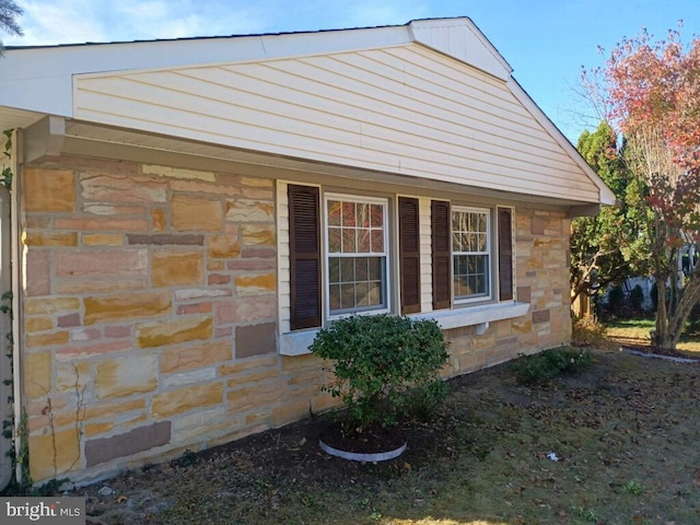 view of side of property with stone siding
