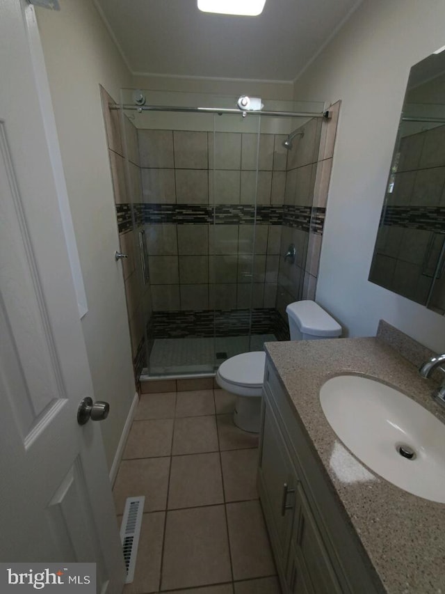 bathroom featuring toilet, visible vents, tile patterned flooring, a shower stall, and ornamental molding