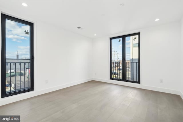 empty room featuring light wood-type flooring and floor to ceiling windows