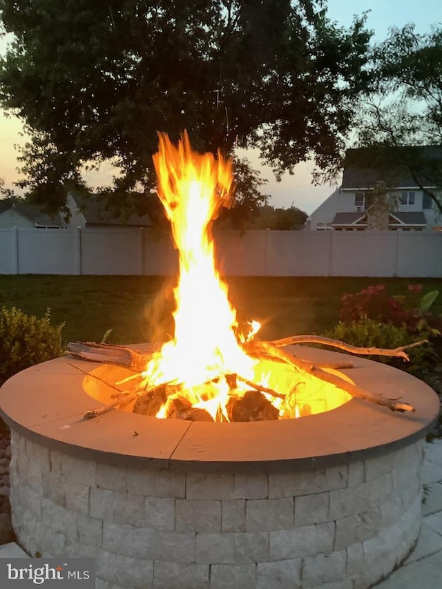 pool at dusk with fence and a fire pit