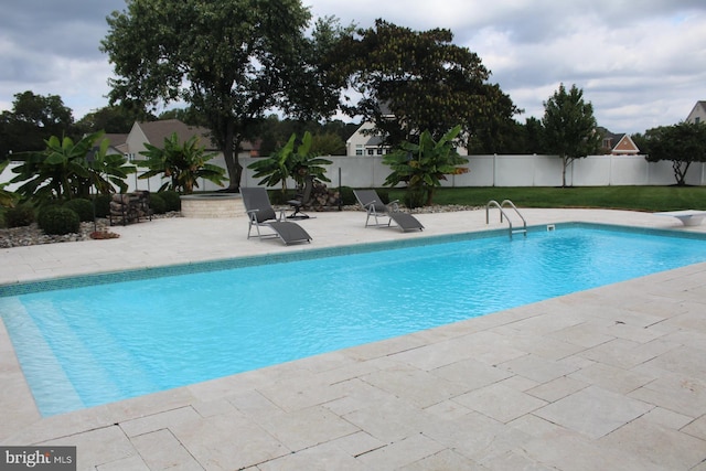 view of swimming pool with a diving board, a patio area, fence, and a fenced in pool