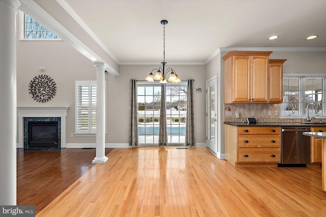 kitchen with a premium fireplace, a sink, decorative backsplash, dishwasher, and decorative columns