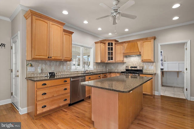 kitchen with light wood-style flooring, custom exhaust hood, stainless steel appliances, crown molding, and a sink