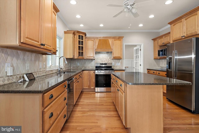 kitchen with stainless steel appliances, a sink, ornamental molding, custom exhaust hood, and a center island