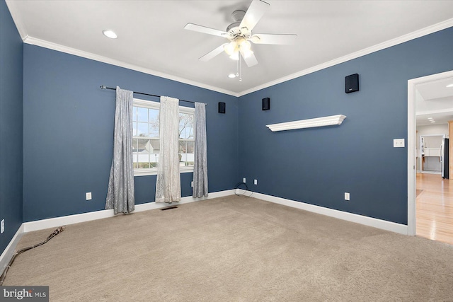 spare room featuring ornamental molding, carpet, visible vents, and baseboards