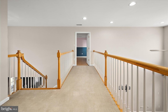 hallway with carpet, recessed lighting, visible vents, an upstairs landing, and baseboards