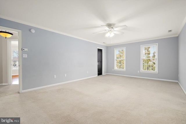 spare room with visible vents, ornamental molding, a ceiling fan, light carpet, and baseboards