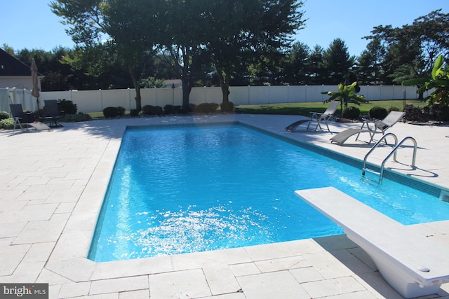 view of pool featuring a fenced backyard, a diving board, a fenced in pool, and a patio