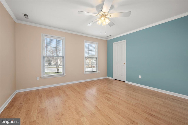 unfurnished room featuring light wood-style floors, visible vents, ornamental molding, and baseboards