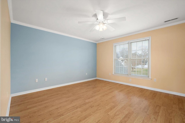 unfurnished room featuring crown molding, baseboards, and wood finished floors