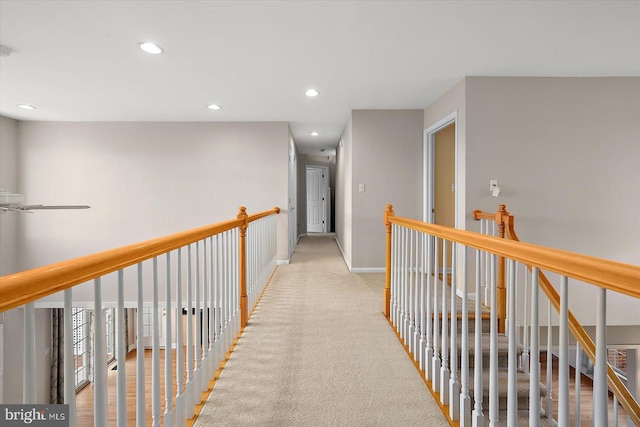 hall with recessed lighting, visible vents, light carpet, an upstairs landing, and baseboards