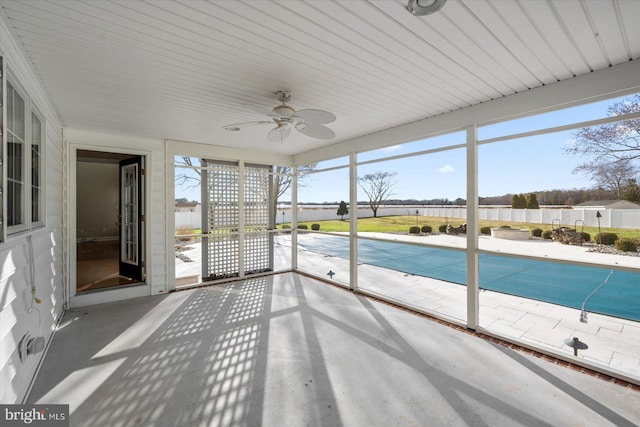 unfurnished sunroom featuring a ceiling fan and a wealth of natural light