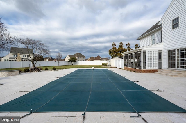 view of swimming pool featuring an outdoor structure, a patio area, and a sunroom