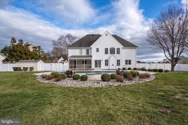 back of house with a fenced backyard, a sunroom, a lawn, a fenced in pool, and a patio area