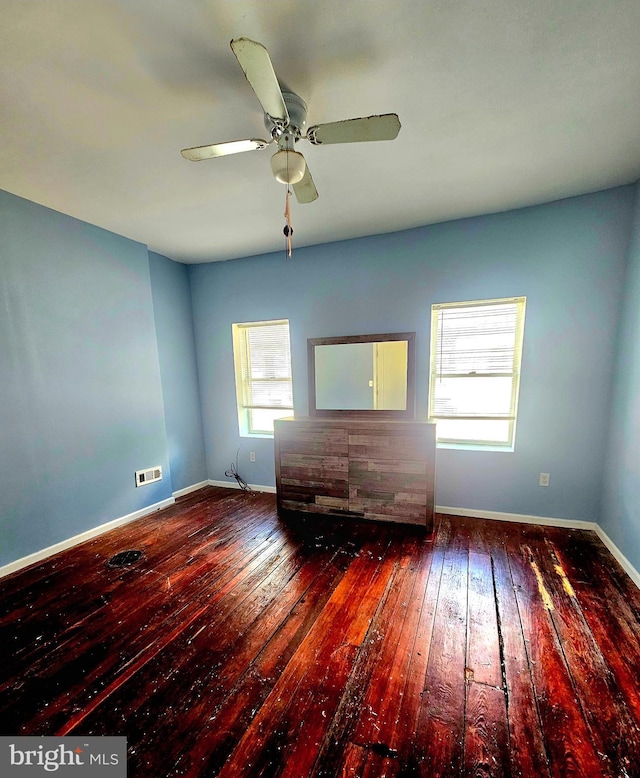 empty room with dark wood-type flooring and ceiling fan