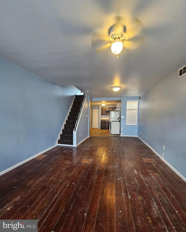 unfurnished living room with ceiling fan and dark hardwood / wood-style flooring