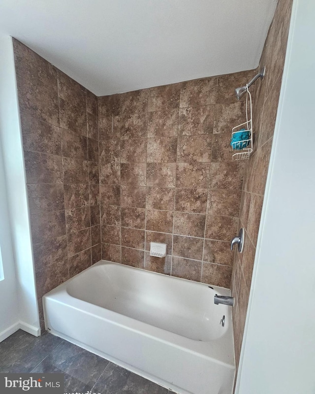 bathroom with tiled shower / bath and tile patterned flooring