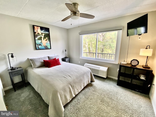 carpeted bedroom with baseboards, a wall unit AC, and ceiling fan