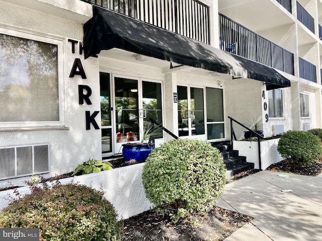 entrance to property with stucco siding and visible vents
