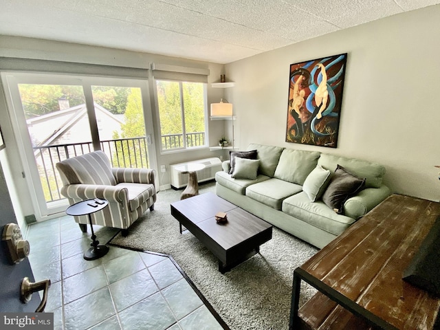 living area featuring tile patterned flooring, a textured ceiling, and a healthy amount of sunlight