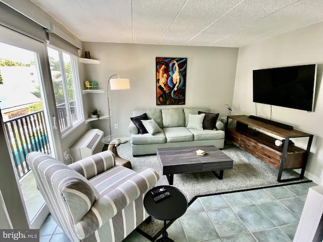 carpeted living area featuring tile patterned floors, a wall mounted AC, and baseboards