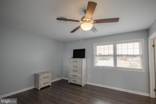 unfurnished bedroom with ceiling fan and dark wood-type flooring