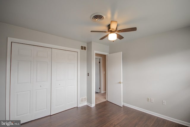 unfurnished bedroom with ceiling fan, a closet, and dark hardwood / wood-style floors