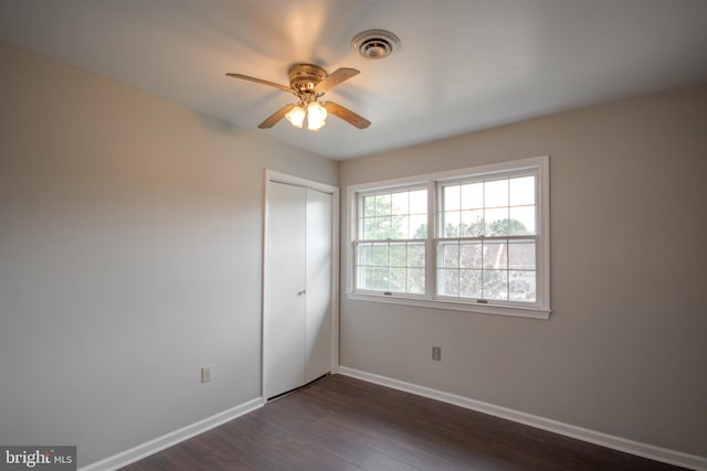 empty room with ceiling fan and dark hardwood / wood-style flooring