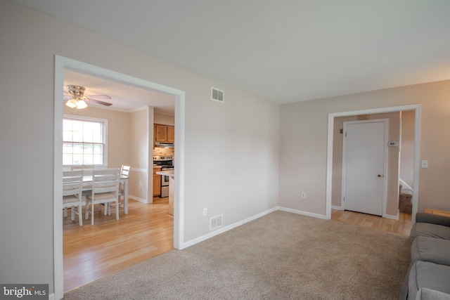 unfurnished living room featuring ceiling fan and light hardwood / wood-style floors