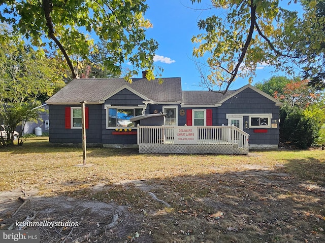 view of front of property featuring a wooden deck and a front lawn