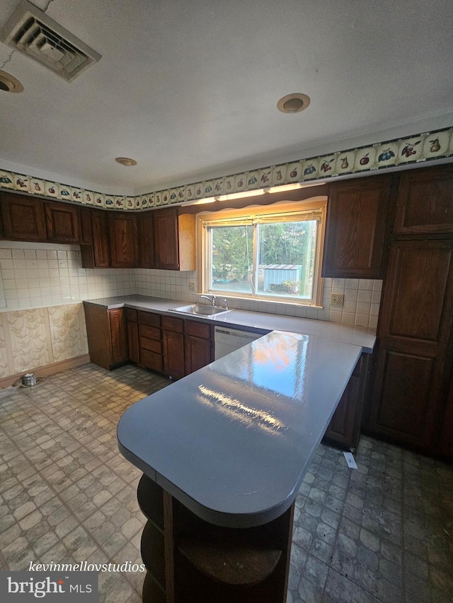 kitchen featuring decorative backsplash, sink, and white dishwasher