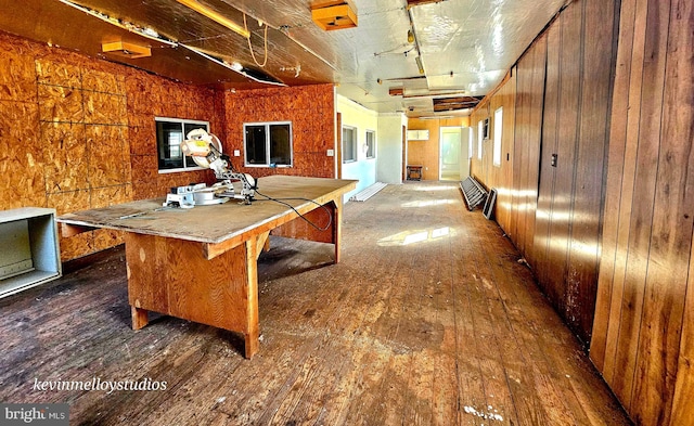 interior space featuring dark wood-type flooring, a kitchen breakfast bar, and wood walls