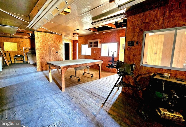 playroom with wooden walls and wood-type flooring