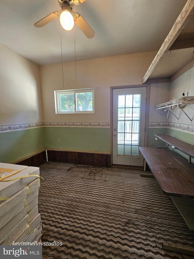 interior space featuring dark carpet and ceiling fan