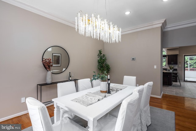 dining area featuring crown molding, light hardwood / wood-style flooring, and an inviting chandelier