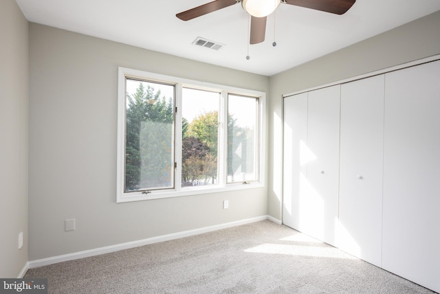 unfurnished bedroom with light carpet, a closet, and ceiling fan