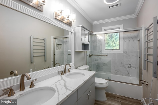 full bathroom with hardwood / wood-style floors, shower / bath combination with glass door, toilet, ornamental molding, and vanity